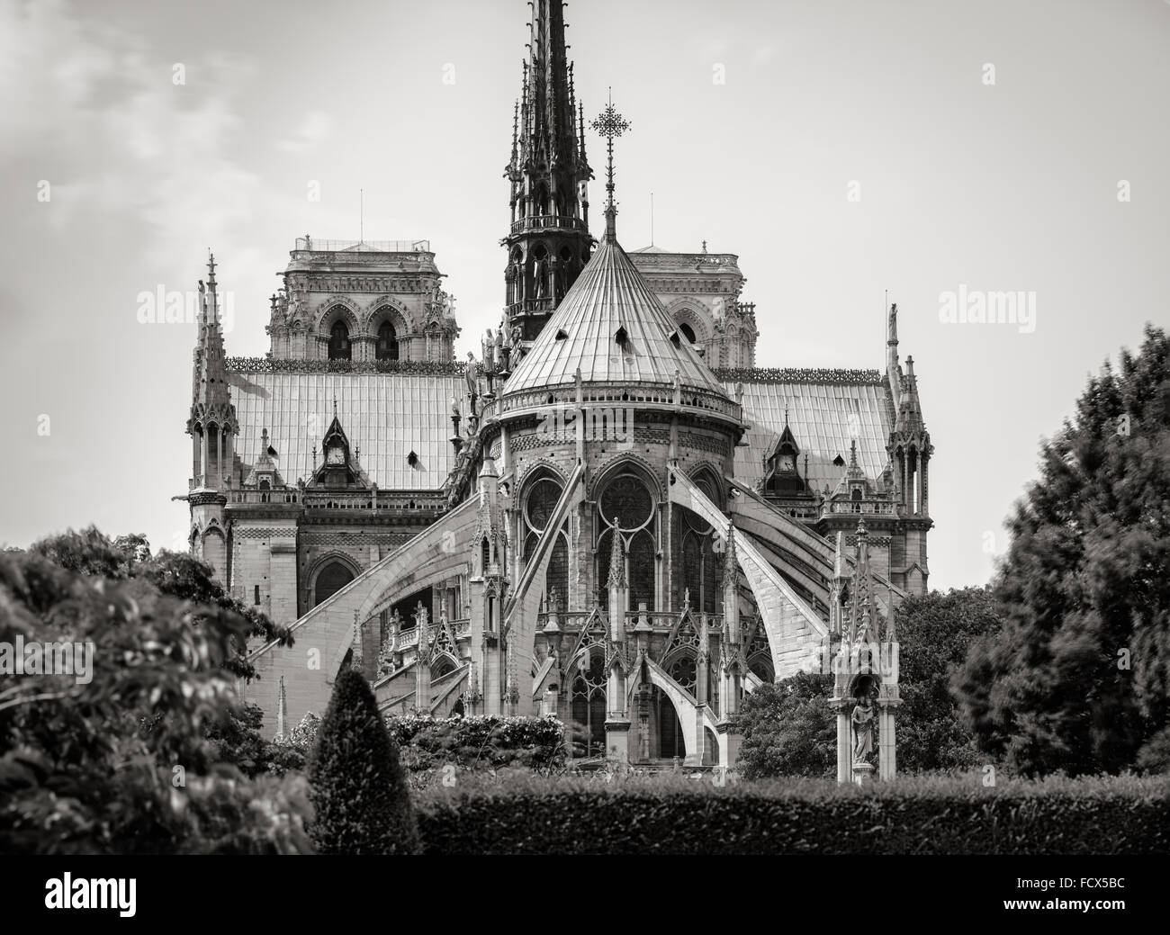 La Cathédrale Notre Dame de Paris détail architectural en noir et blanc montrant des arcs-boutants, les deux tours et spire. France Banque D'Images