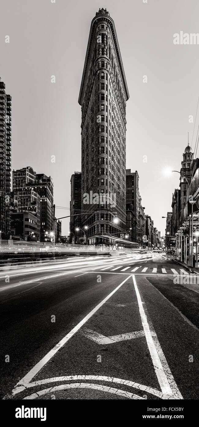 Flatiron Building en noir et blanc avec la voiture tout en légèreté sur la 5e Avenue, à la brunante à Midtown Manhattan, New York City Banque D'Images