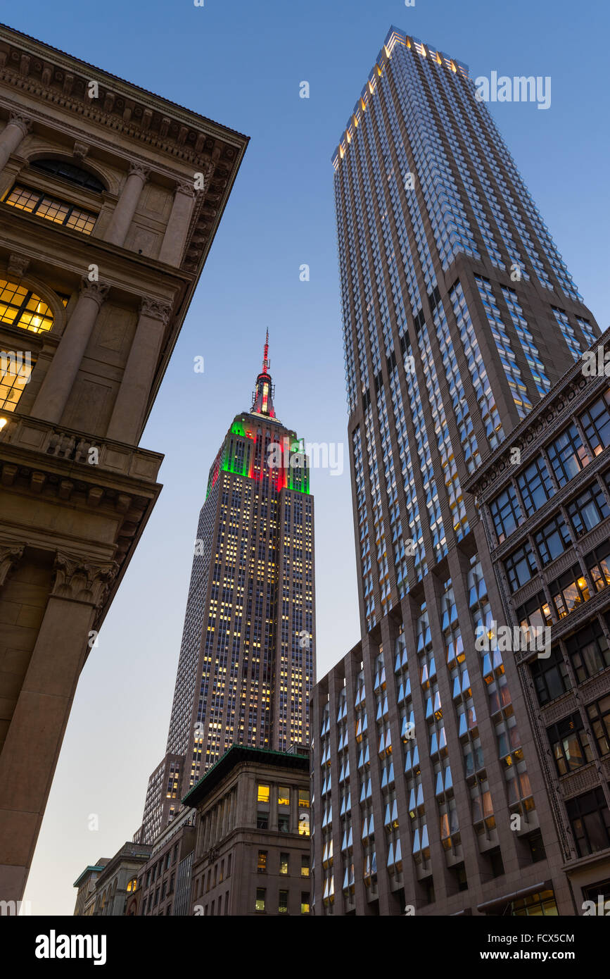 Au crépuscule de l'Empire State Building illuminé de rouge, vert et blanc des lumières de Noël. La 5ème Avenue, Manhattan, New York City Banque D'Images