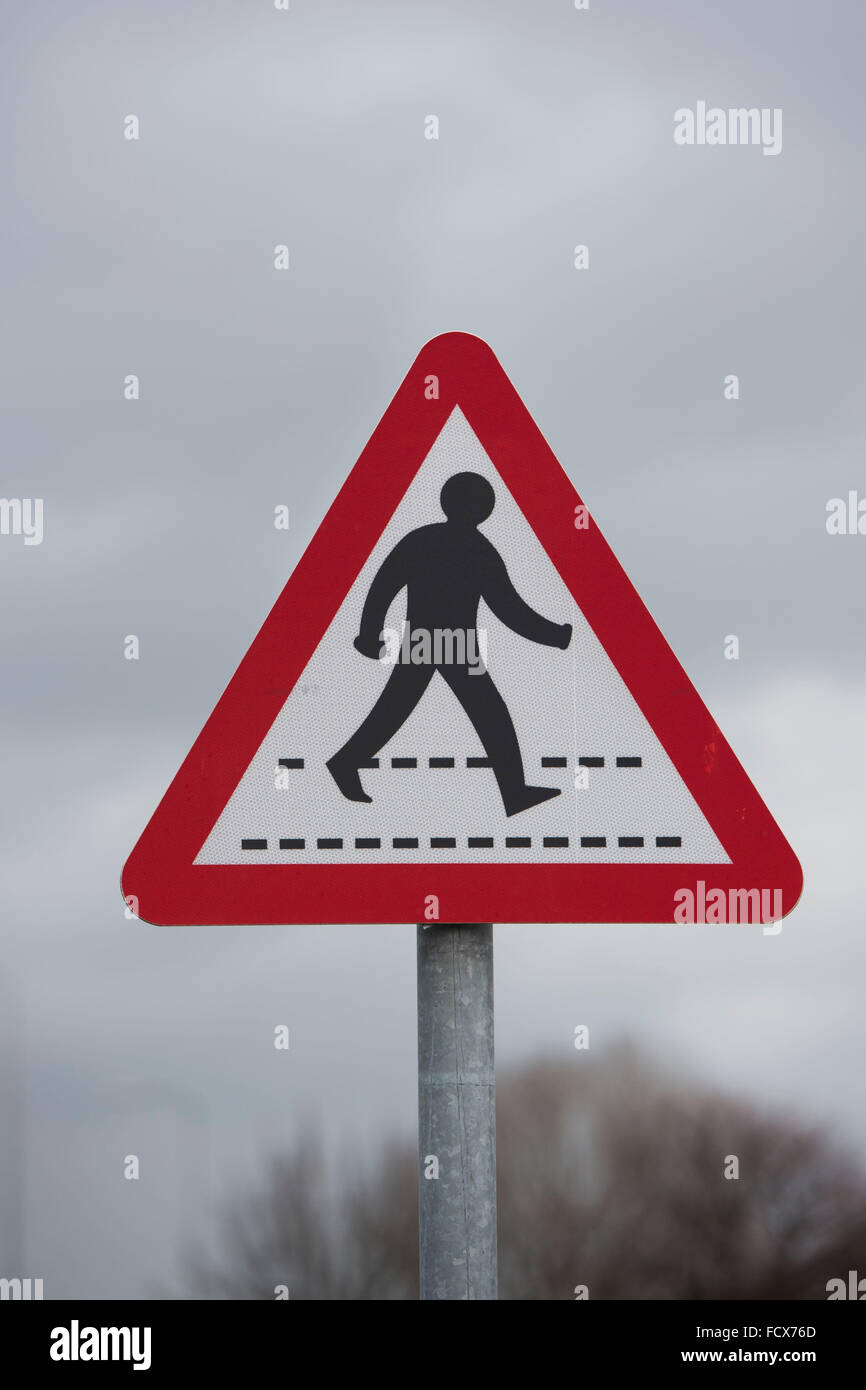 Balades piétons panneau de passage à niveau contre un ciel sombre. Banque D'Images