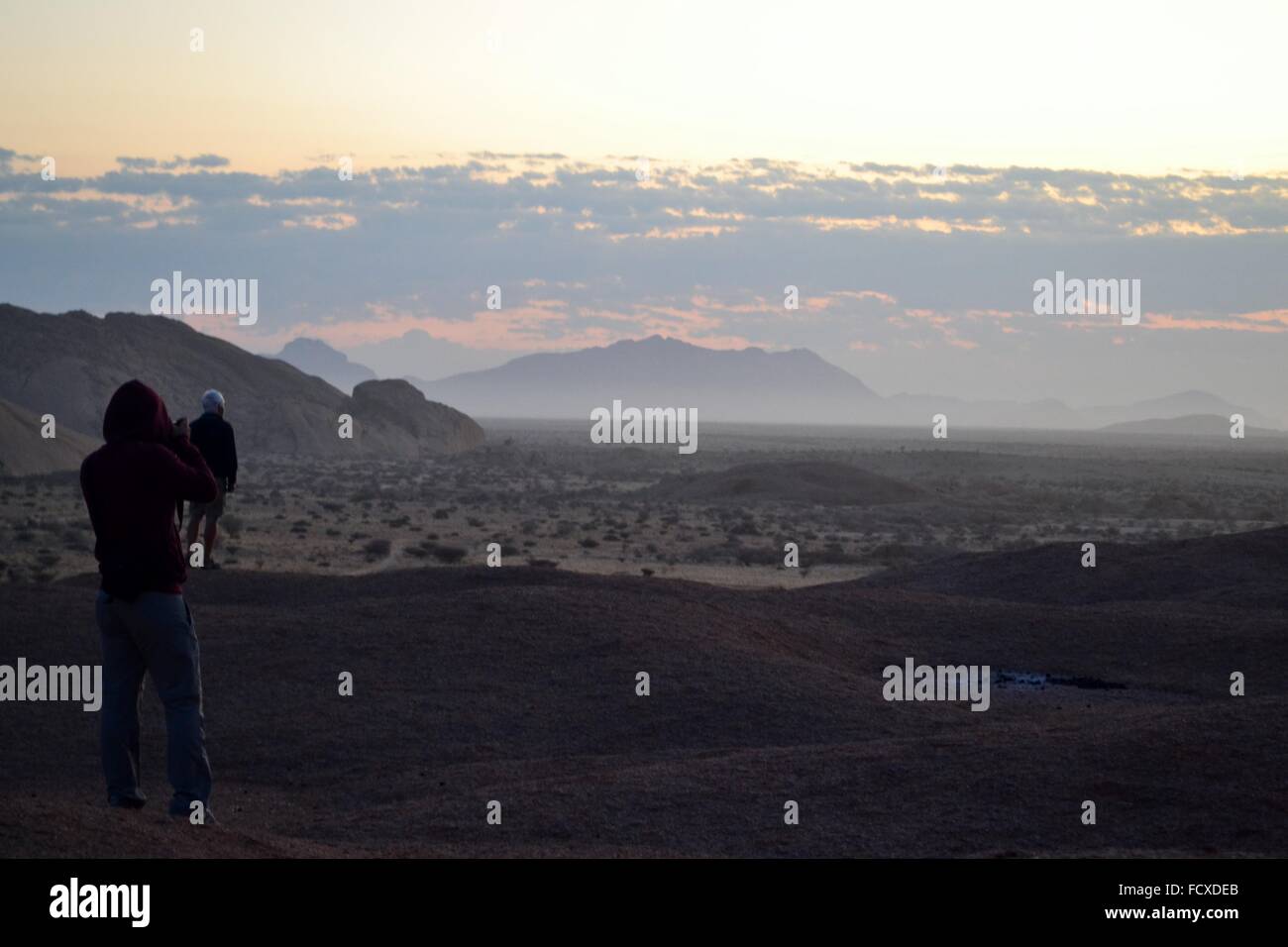 Deux voyageurs voir le soleil se lever près de Mount Spitzkoppe en Namibie, Afrique Banque D'Images