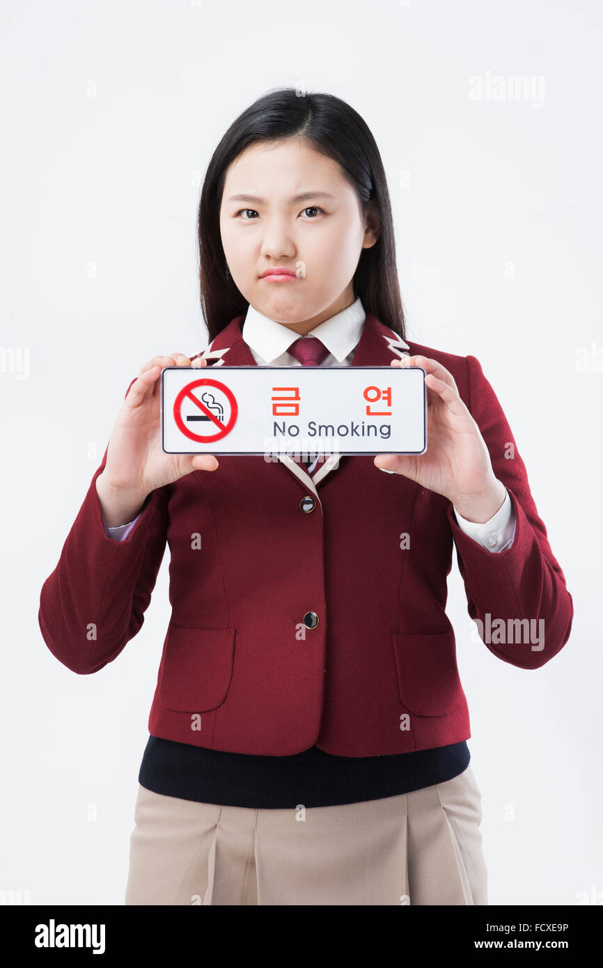 High school girl in school uniform holding aucun signe de fumer en fronçant face Banque D'Images