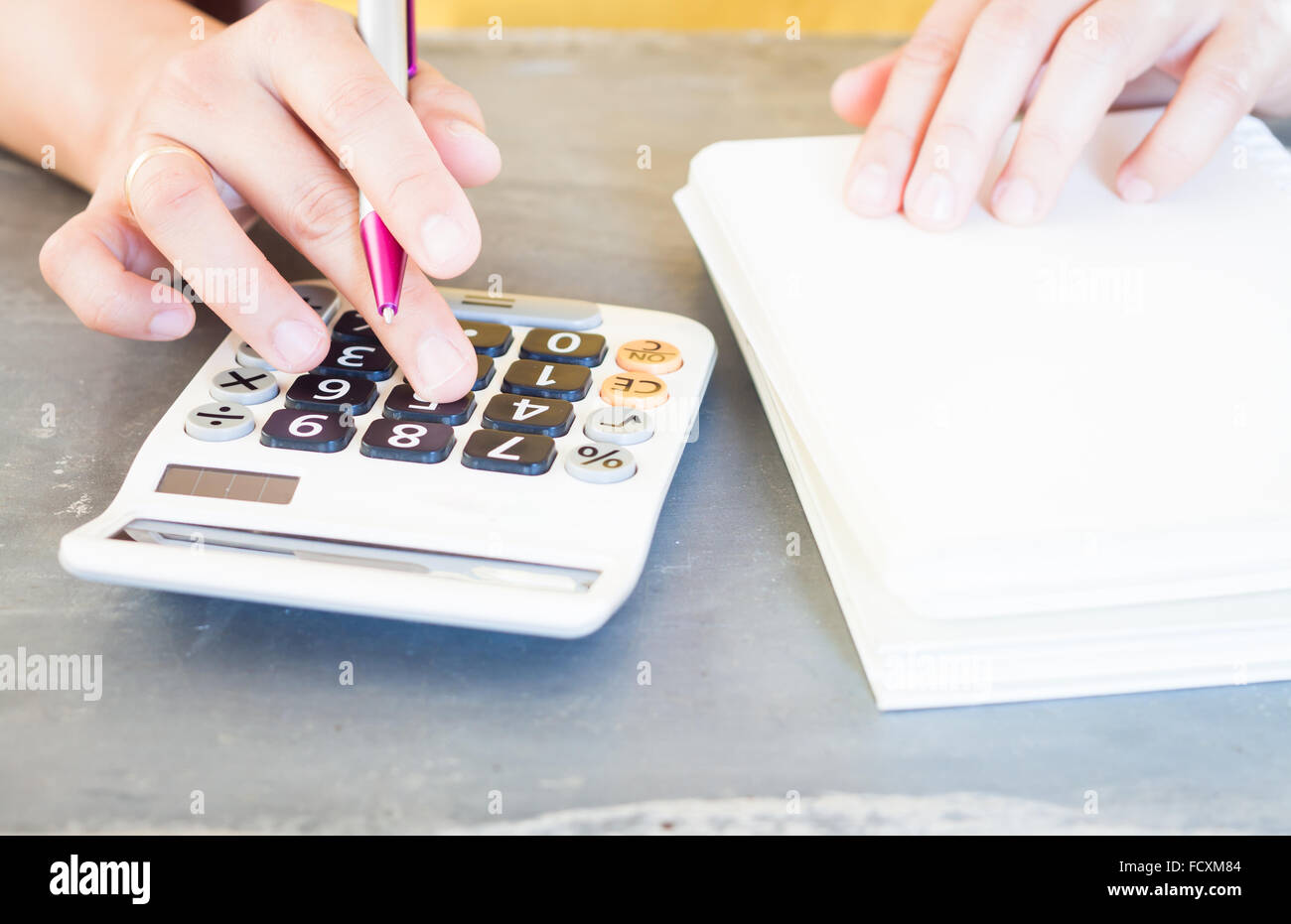 Hand holding pen et en appuyant sur les boutons de la calculatrice, stock photo Banque D'Images