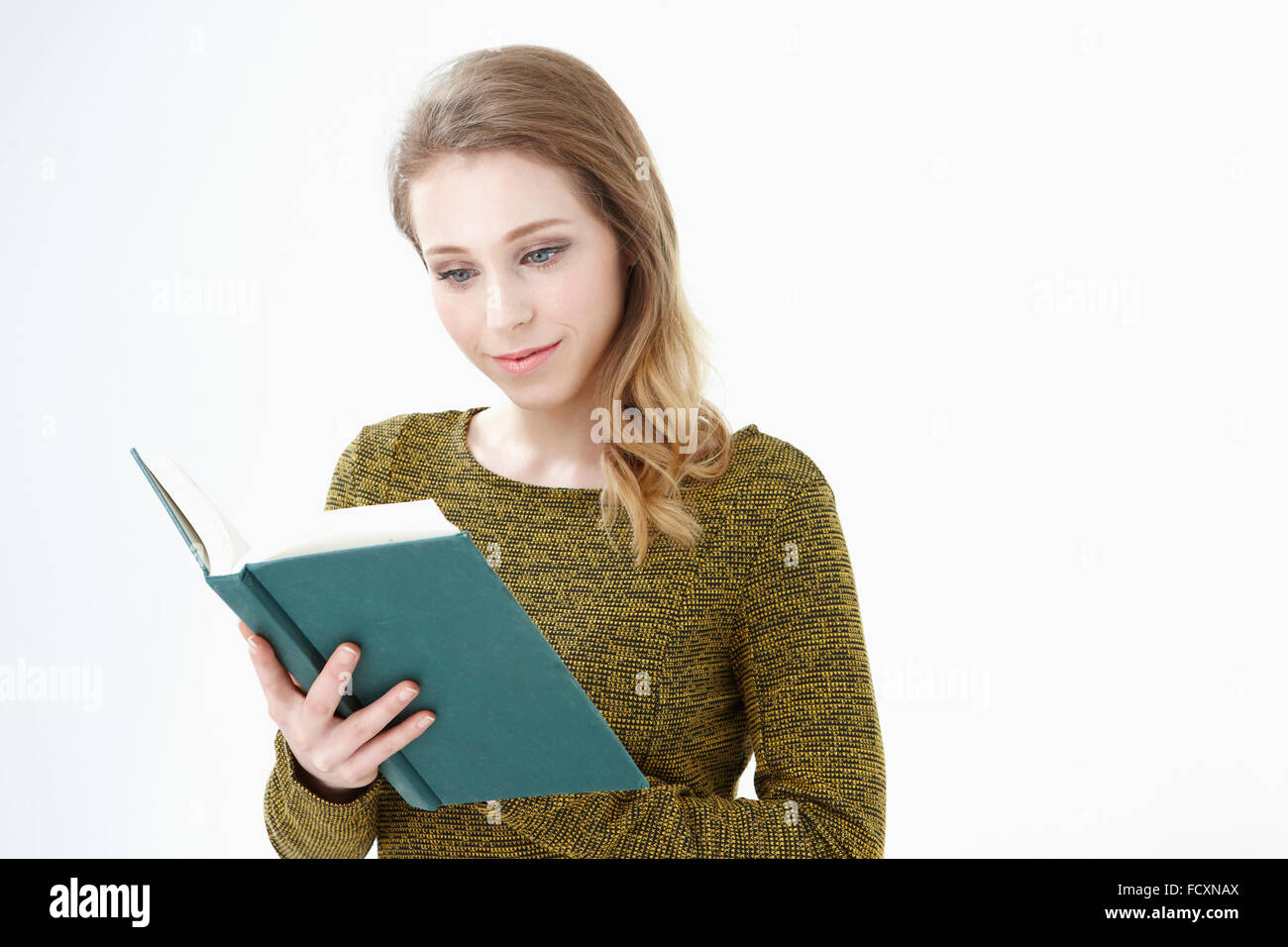 Portrait of young smiling woman reading a book Banque D'Images