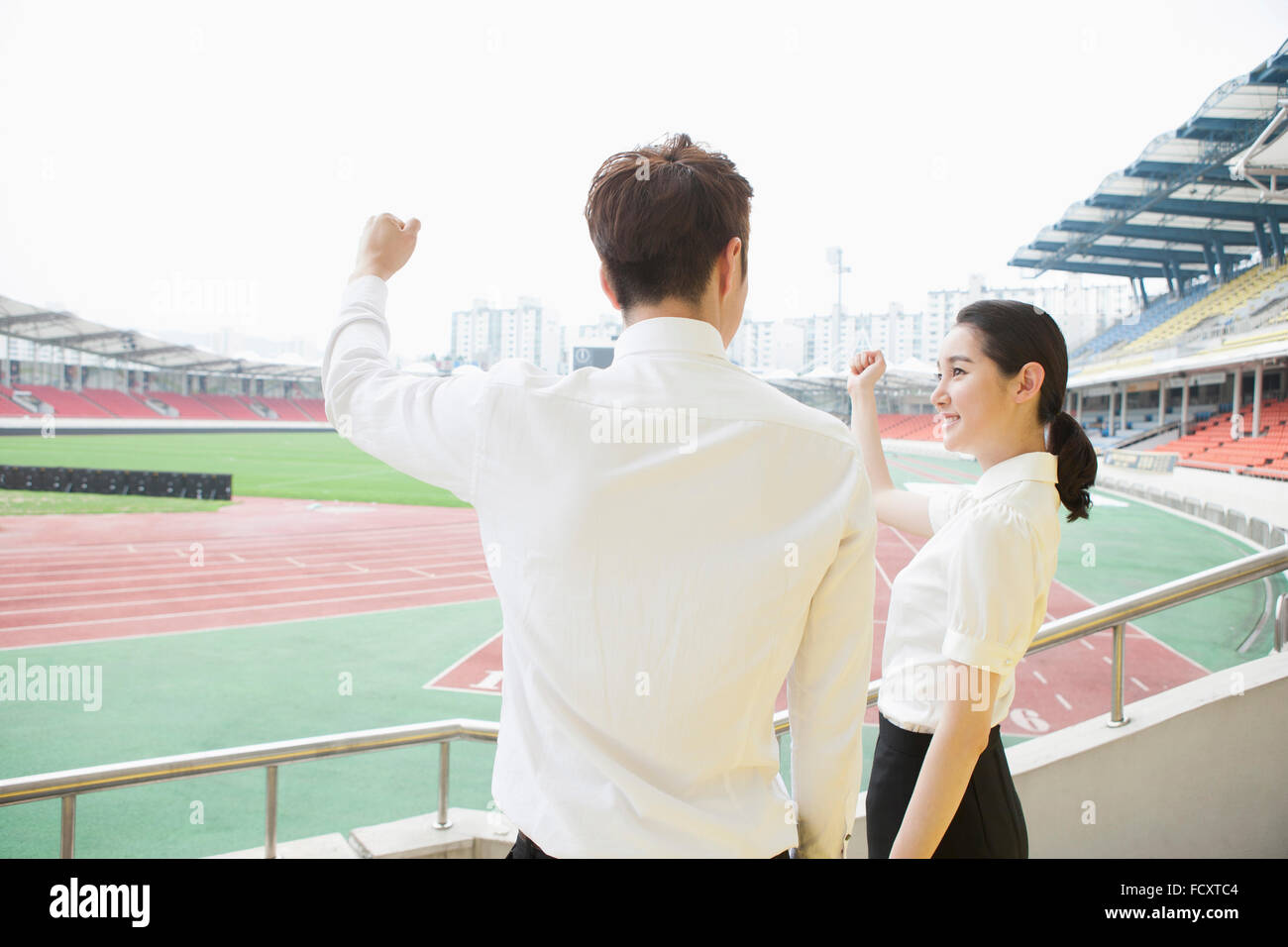 Dos de businessman cheering at stadium Banque D'Images