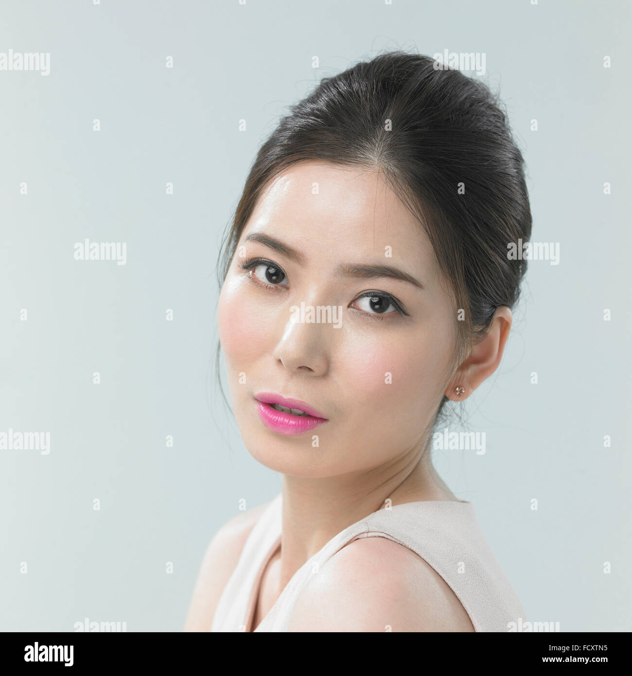 Pirtrait de jeune femme aux lèvres roses et cheveux attachés Banque D'Images