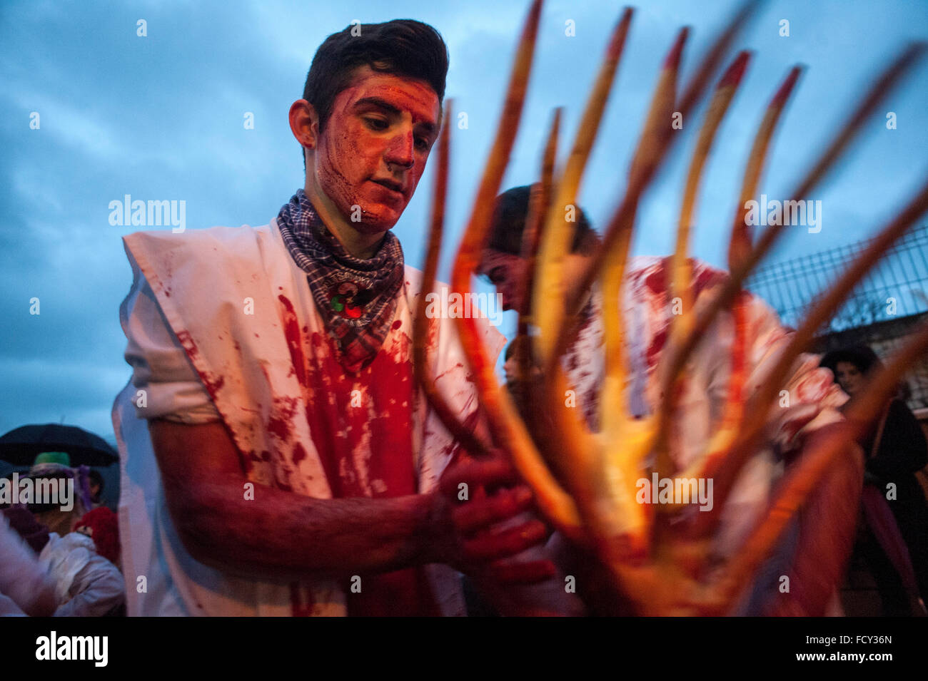 Un participant dans le carnaval de Alsasua enduit son trident avec du sang de vache avant la parade dans les rues de la ville Banque D'Images