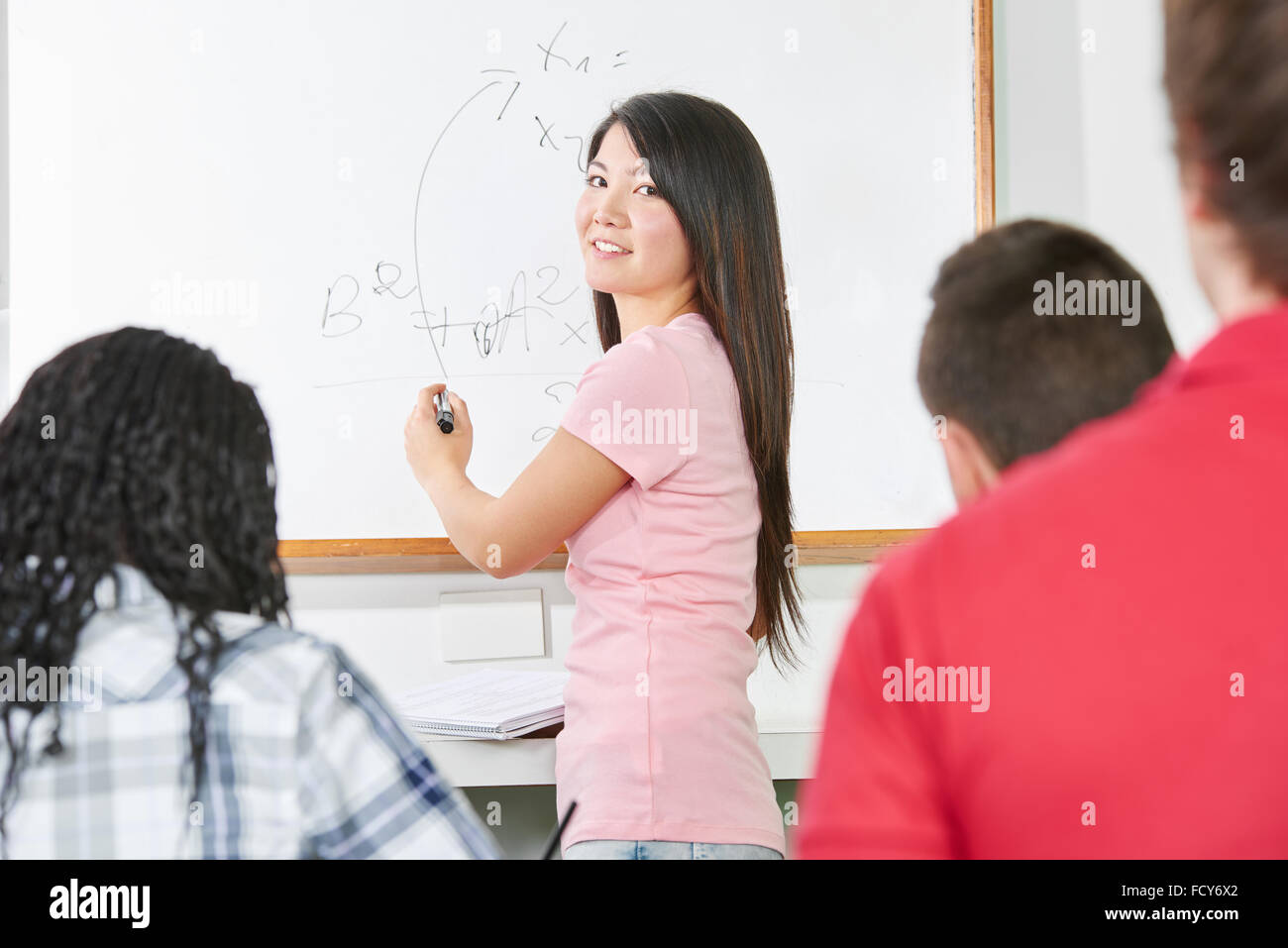 Élève résout une formule mathématique en avant de la classe Banque D'Images