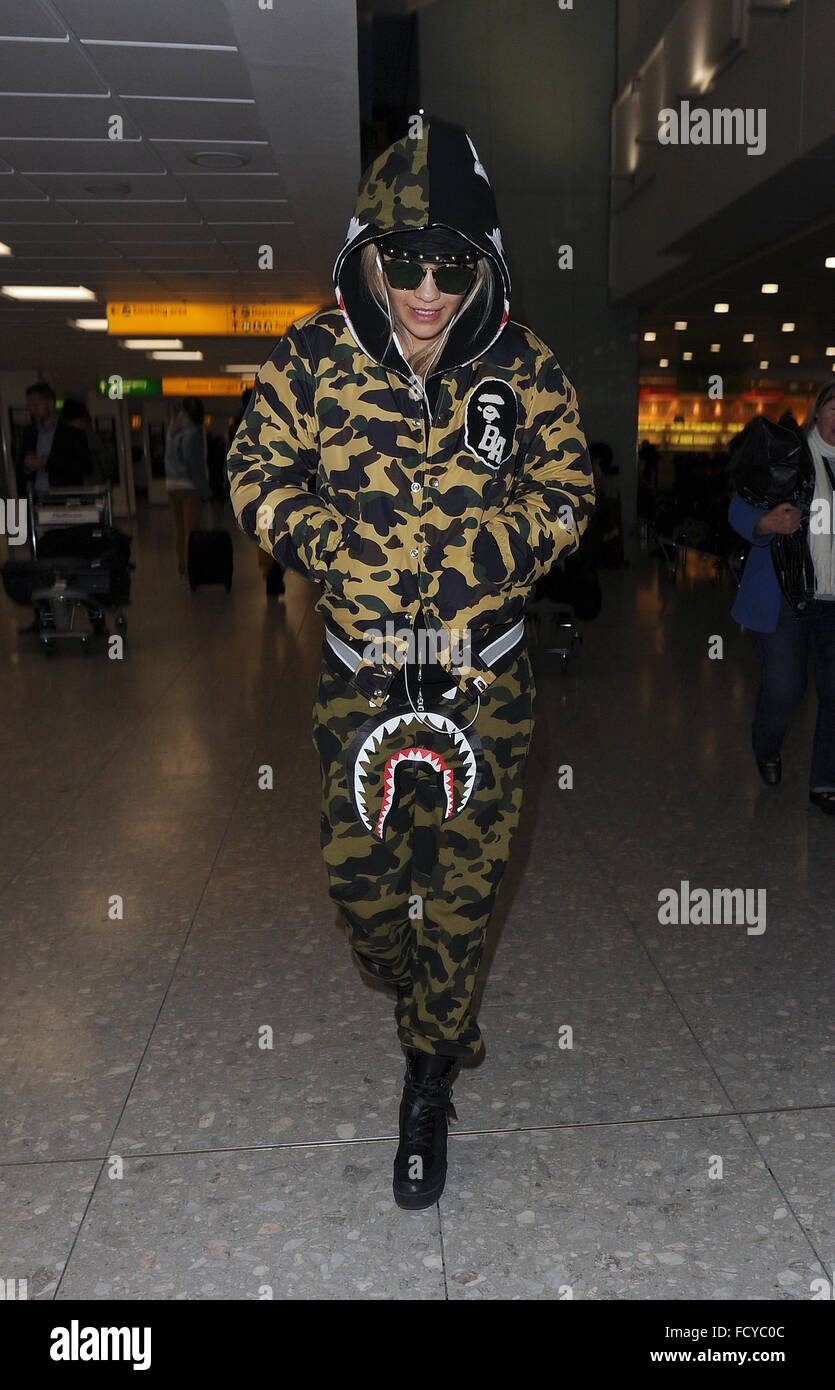 Rita Ora arrive à la maison pour Noël, sur un vol en provenance de Hong Kong, avec sa sœur Elena Ora. Ria était vêtu d'un survêtement camouflage du BAPE, avec un visage effrayant imprimé sur l'entrejambe. Les deux sœurs l'air fatigué, mais étaient en très bonne humeur qu'ils ont fait leur Banque D'Images