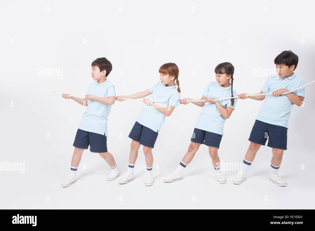 Apparition de quatre du côté de l'école élémentaire dans les vêtements de sport dans une équipe faisant remorqueur de la guerre Banque D'Images