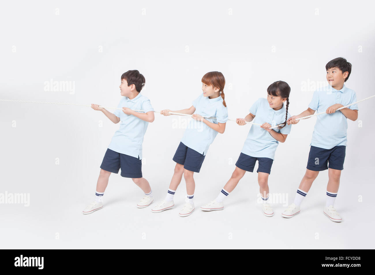 Apparition de quatre du côté de l'école élémentaire dans les vêtements de sport dans une équipe faisant remorqueur de la guerre Banque D'Images