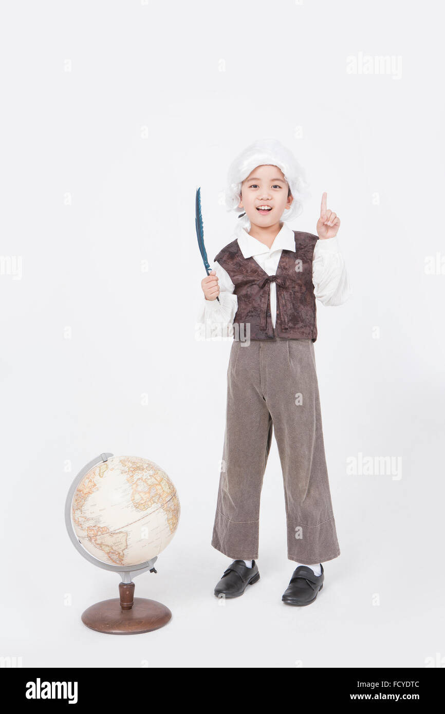 Garçon dans le style érudit classique debout derrière un globe avec un stylo plume et avec son doigt pointé vers le haut Banque D'Images