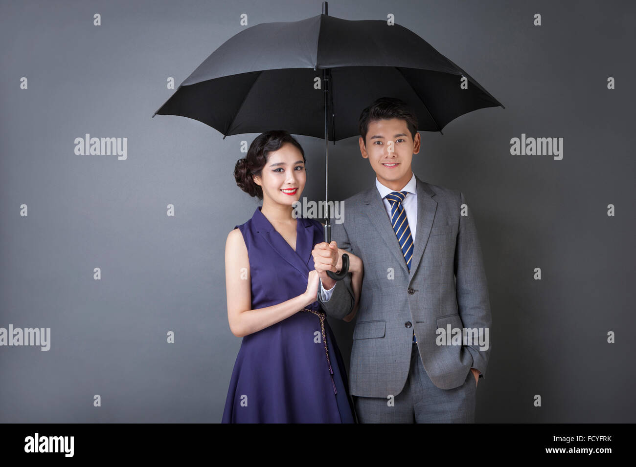 L'homme en costume et cravate dans un style rétro et de la femme en robe de style rétro dans le même sac et souriant Banque D'Images