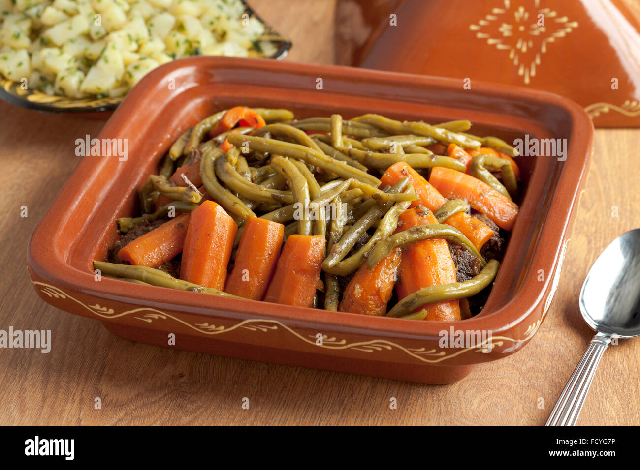 Tajine marocain square avec de la viande, les haricots verts et les carottes sur la table Banque D'Images