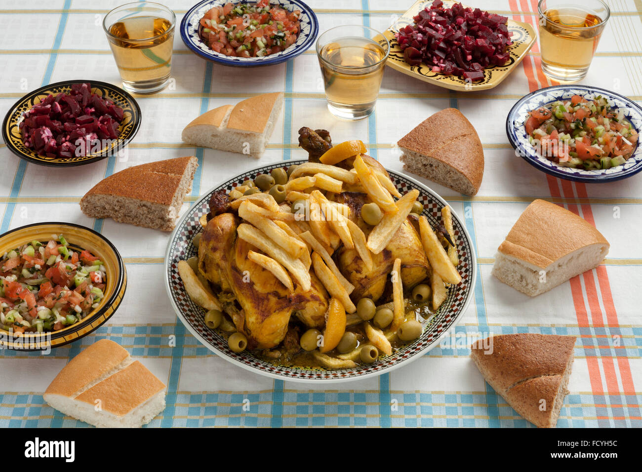 La farine de poulet farcies marocain traditionnel avec des frites, des olives, du pain,citron,préservés et des salades sur la table Banque D'Images