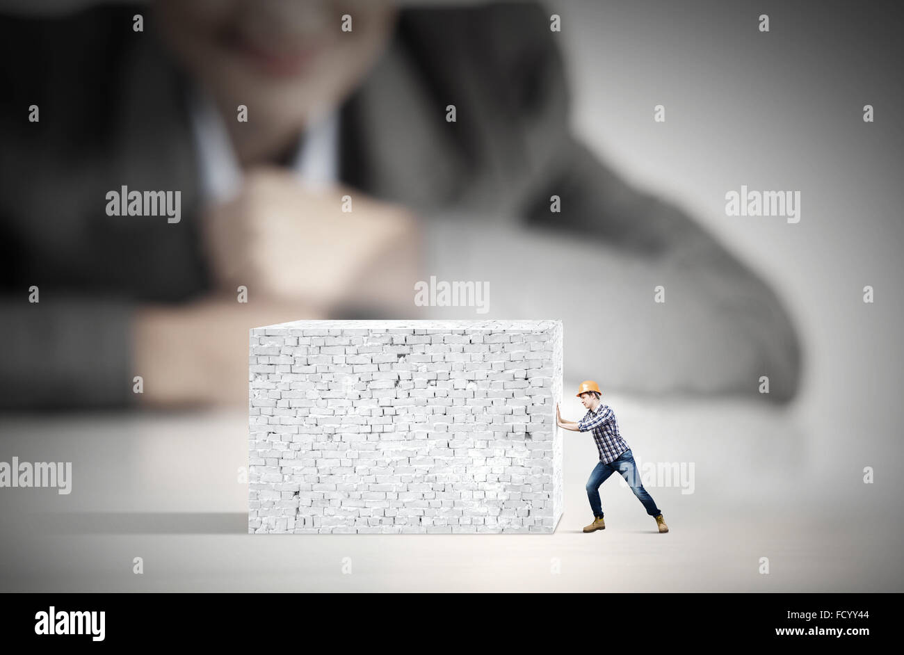 Businesswoman looking at man in hardhat tirant brick wall Banque D'Images Businesswoman looking at man in hardhat tirant brick wall Banque D'Images