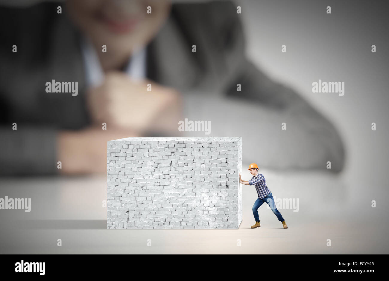 Businesswoman looking at man in hardhat tirant brick wall Banque D'Images Businesswoman looking at man in hardhat tirant brick wall Banque D'Images
