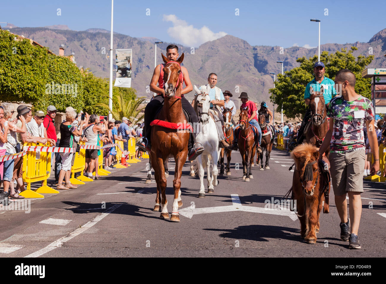 Les cavaliers et leurs chevaux le long de la rue de la plage de La Enramada où ils le bain des animaux. Fiesta de San Saba Banque D'Images