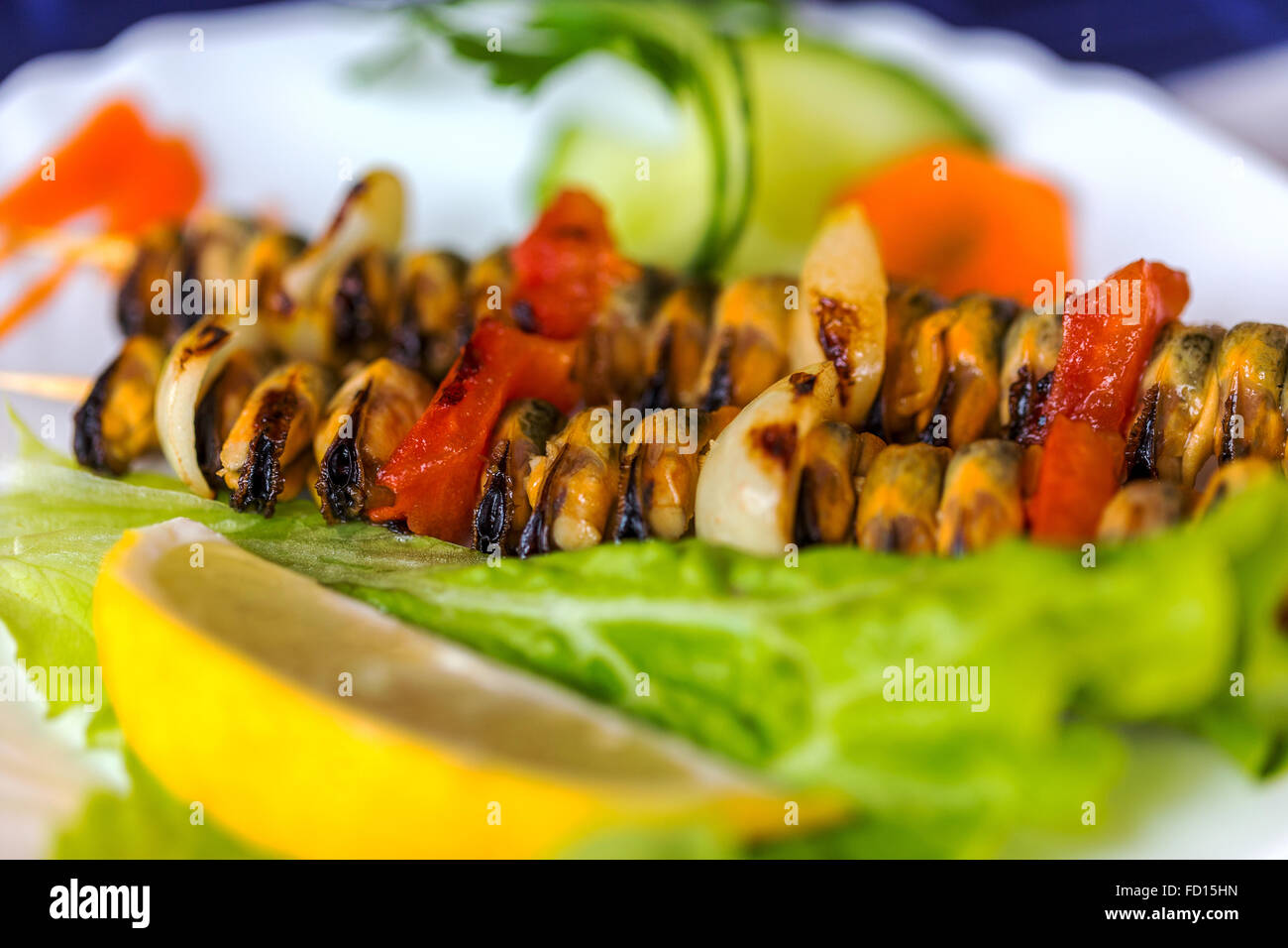 Les moules frais grillé aux herbes et citron sur plaque blanche, selective focus Banque D'Images