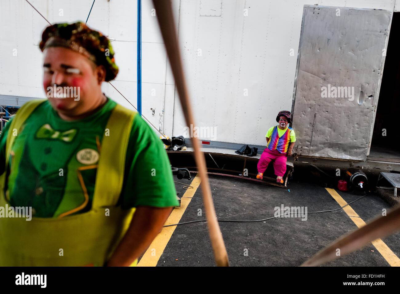 Un clown nain prend un repos, de concert avec son collègue, dans le clown de cirque backstage Renato, à San Salvador, El Salvador. Banque D'Images
