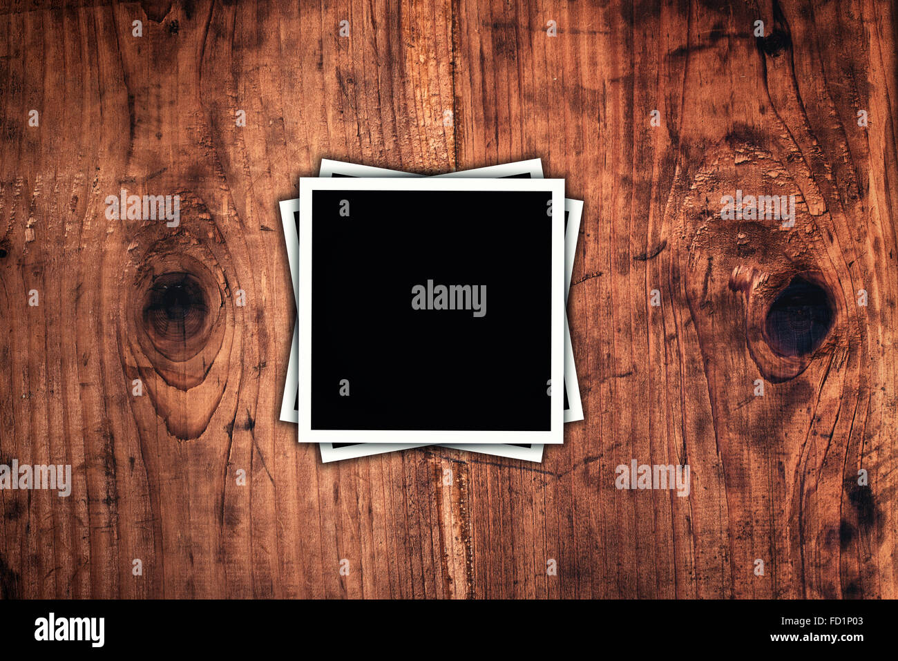 Format carré blanc photos sur un bureau en bois rustique comme copy space Banque D'Images