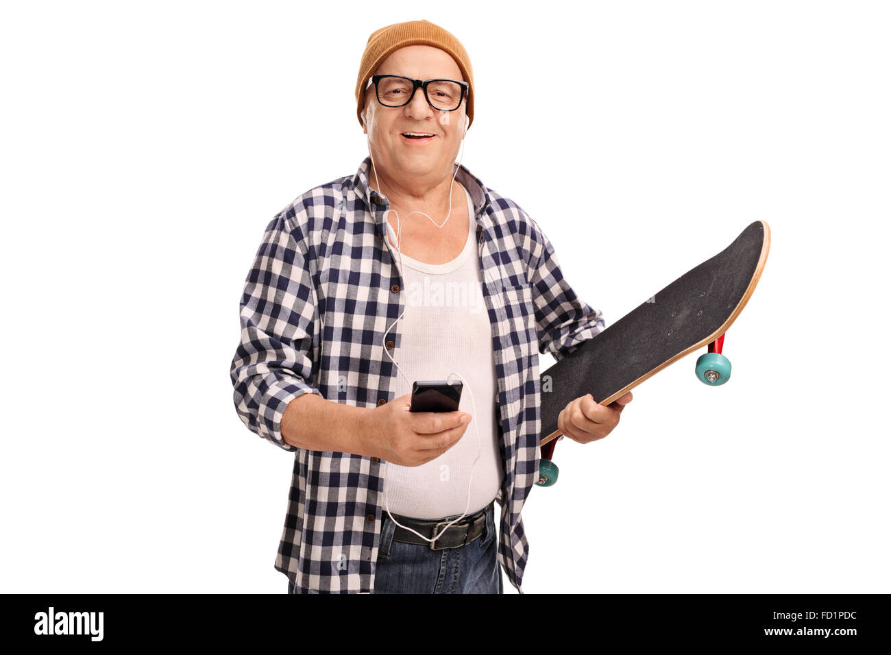 La tenue d'un patineur senior Cool skateboard et l'écoute de la musique sur un casque isolé sur fond blanc Banque D'Images