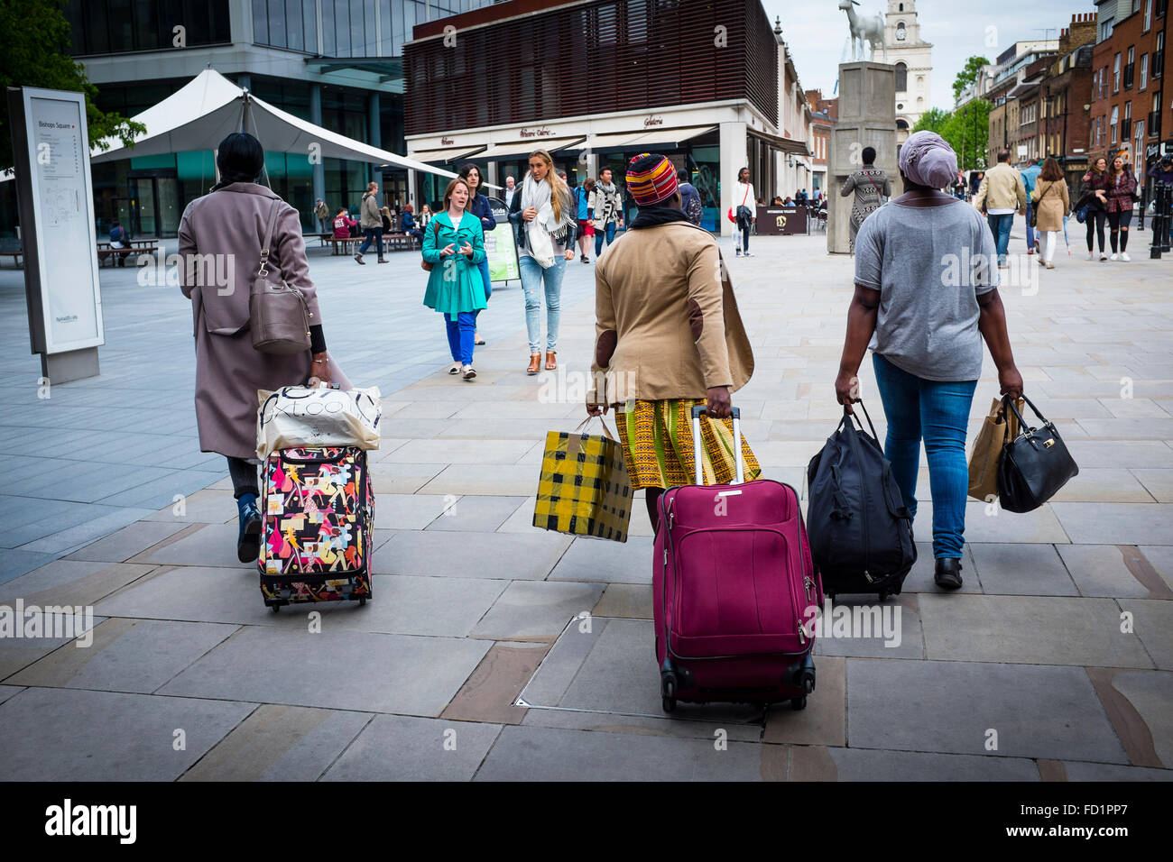 Trois femmes noires tirant une assurance avec des roues dans les rues de Londres, Royaume-Uni Banque D'Images