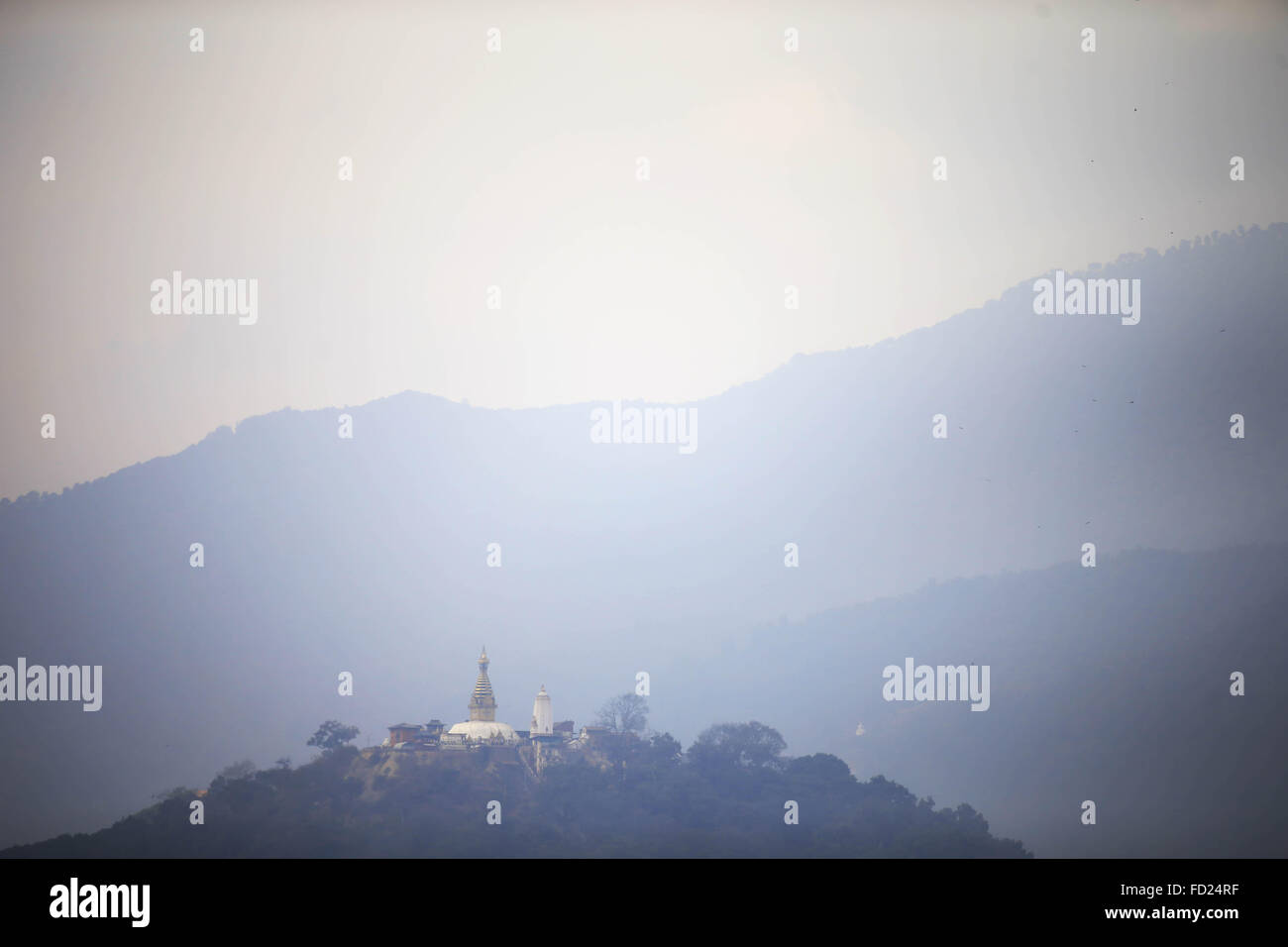 Katmandou, Népal. 27 Jan, 2016. Une scène de la vallée de Katmandou couverte de brume, agile comme le haut de Swayambhunath Stupa au sommet d'une colline est vu de Kasthamandap, Katmandou, Népal le mercredi, 27 janv., 2016. Swayambhunath Stupa est répertorié dans le patrimoine mondial de l'UNESCO. © Skanda Gautam/ZUMA/Alamy Fil Live News Banque D'Images