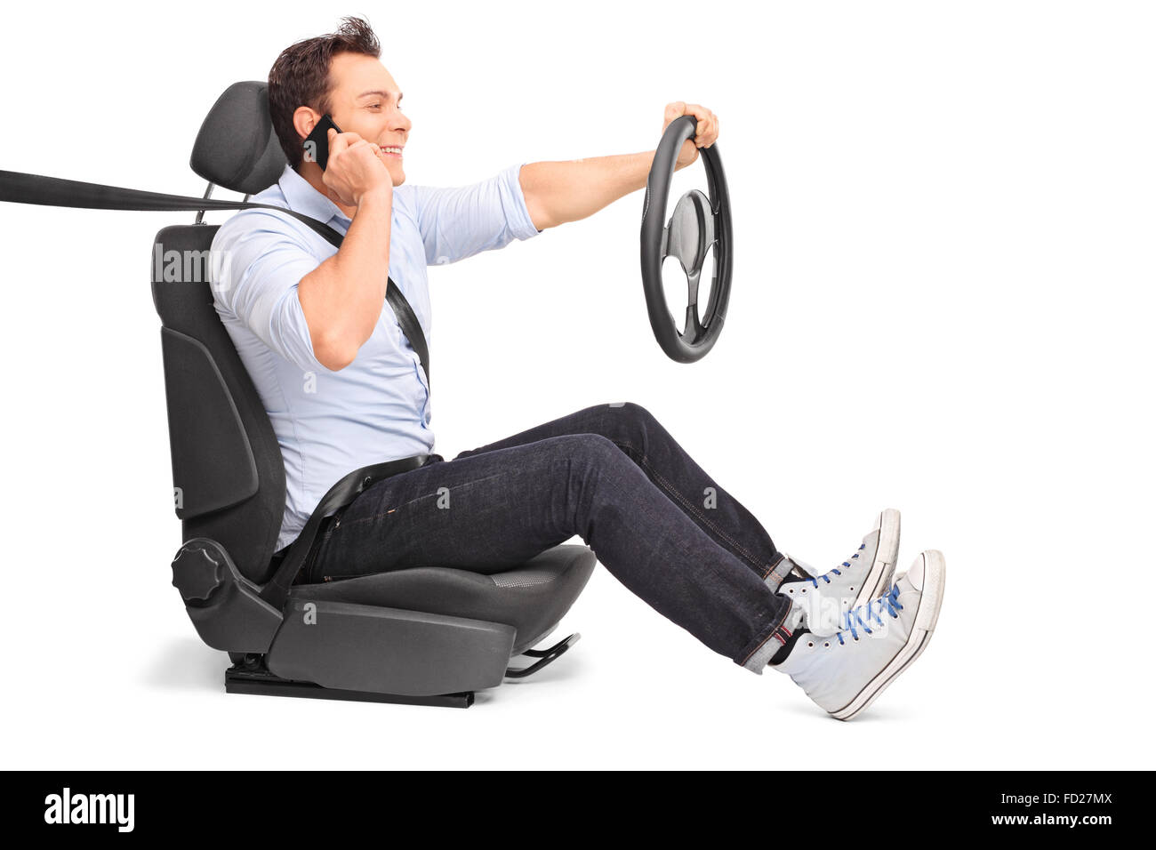 Jeune homme au volant et de parler sur son téléphone cellulaire isolé sur fond blanc Banque D'Images