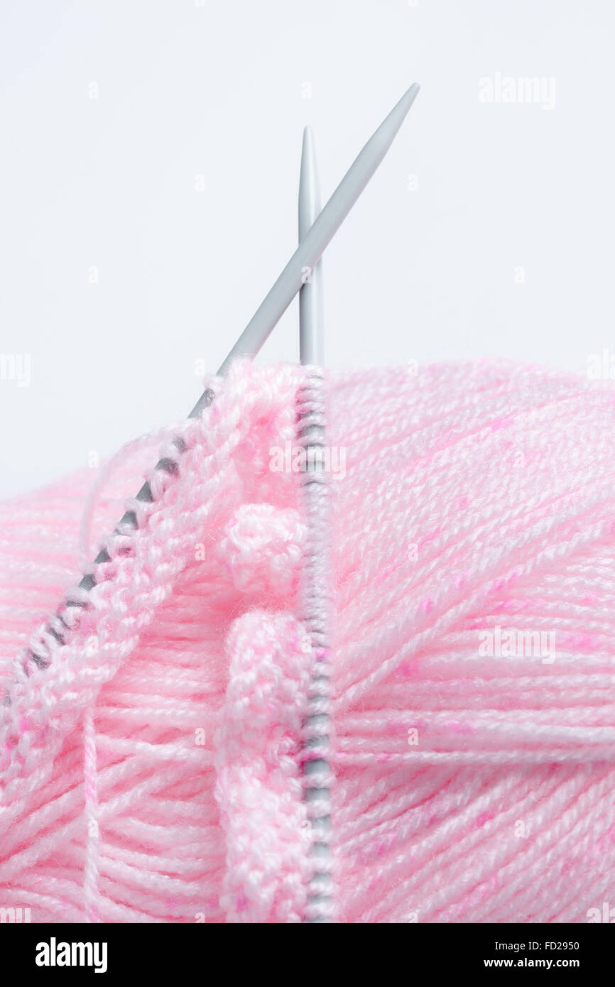 Aiguilles à tricoter et une balle de laine rose un concept d'aiguille à tricoter ou Banque D'Images