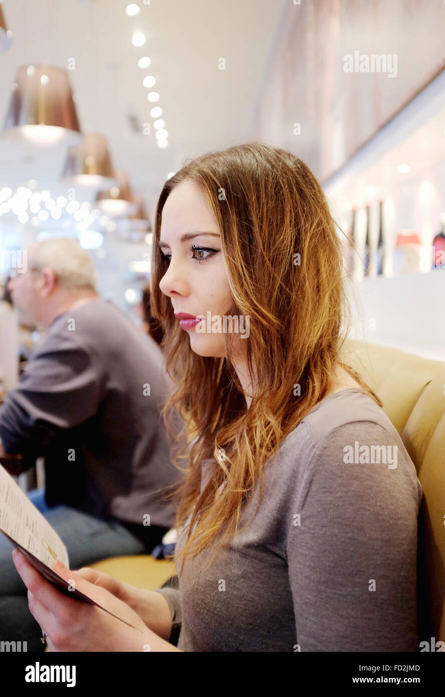 Young woman reading menu restaurant navigation Banque D'Images