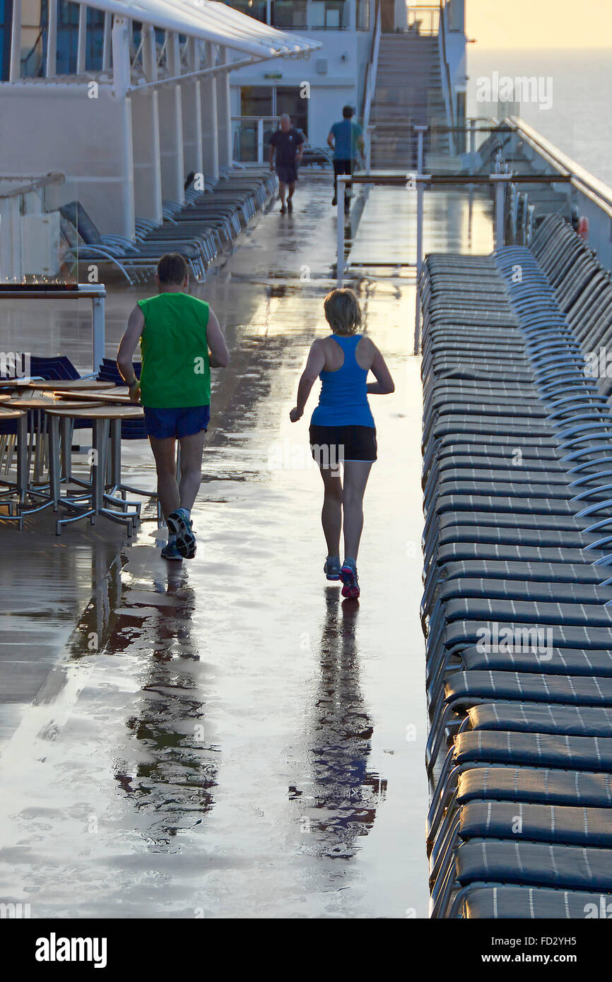 Tôt le matin, les coureurs de l'exercice avec soin le long circuit de course croisière dédié entre les chaises longues après la pluie tombée pendant la nuit Banque D'Images