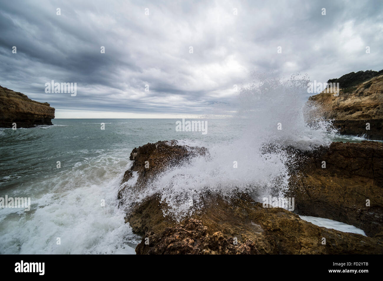 Vagues se brisant sur des rochers à Praia de Albandeira dans la région de l'Algarve du Portugal. Banque D'Images