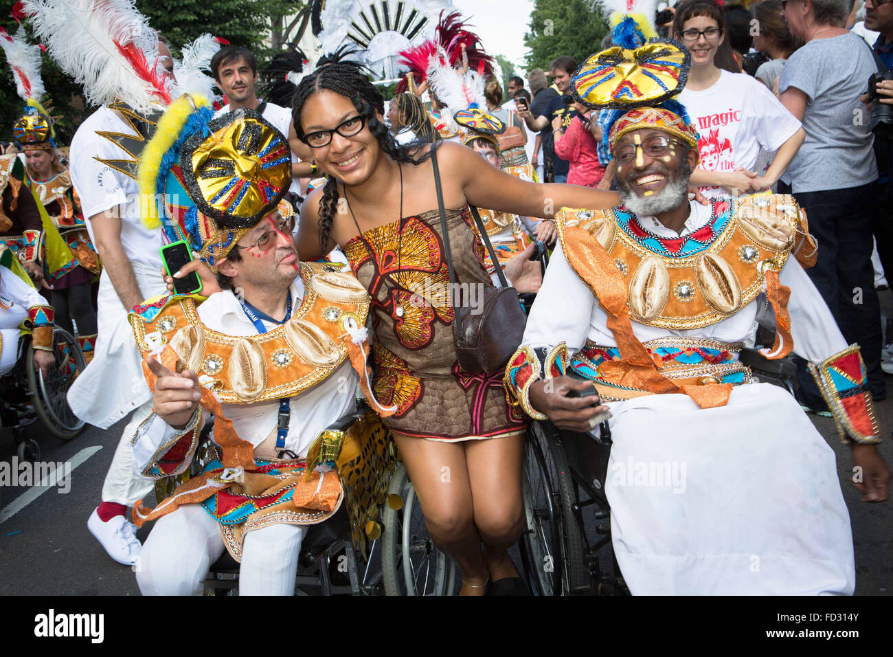 Membre de la foule se joint à deux hommes ayant une déficience qui prennent part à la Notting Hill Carnival 2013 Banque D'Images