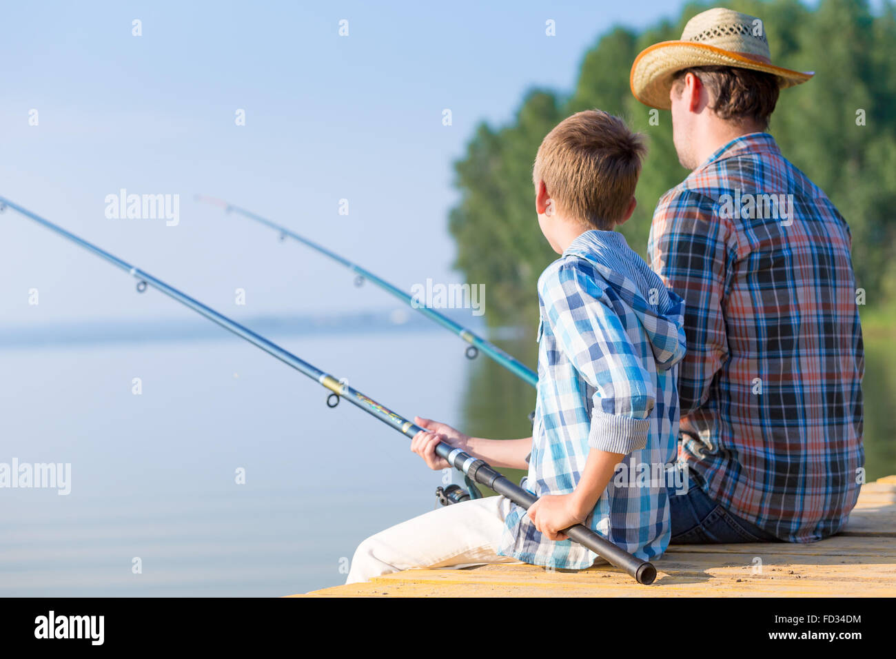 Garçon et son père pêche ensemble à partir d'un quai Banque D'Images