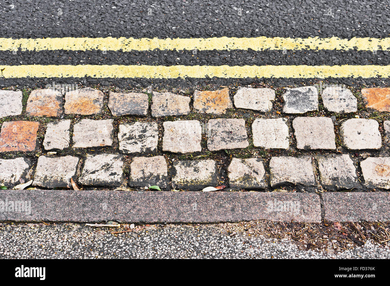 Double yellow lines et le bord d'un trottoir sur le côté d'une route Banque D'Images