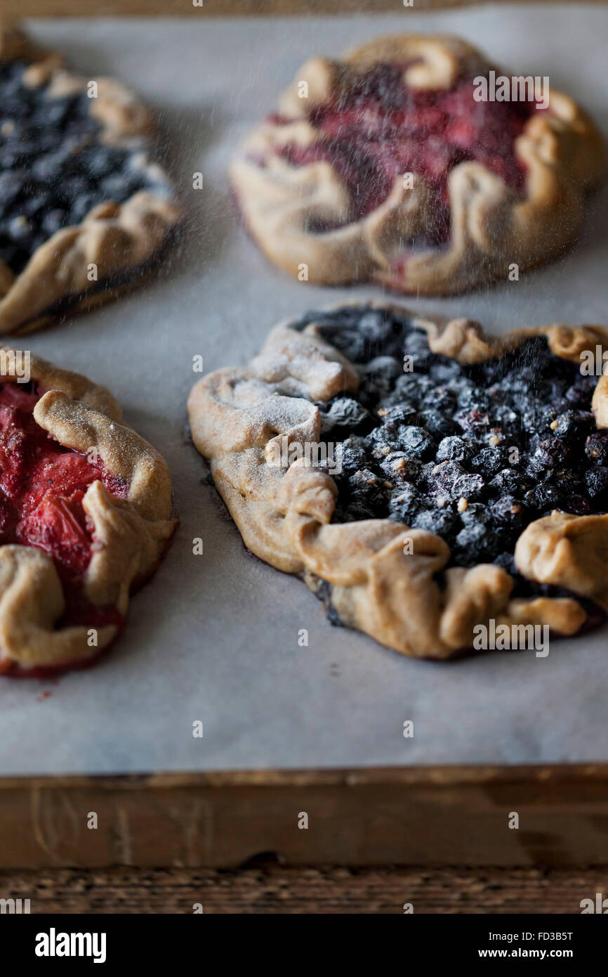 Des fraises et galettes aux bleuets sur la table saupoudrée de sucre en poudre Banque D'Images