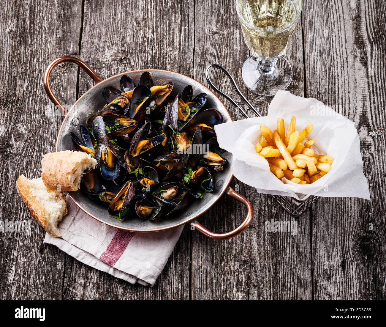 Moules, frites et vin sur fond de bois Banque D'Images