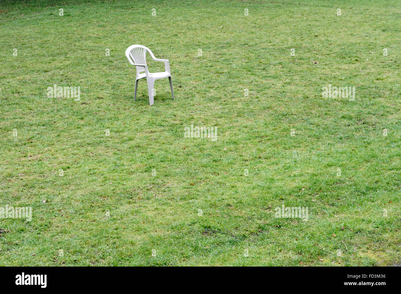 Chaise vide dans le milieu du champ d'herbe verte Banque D'Images