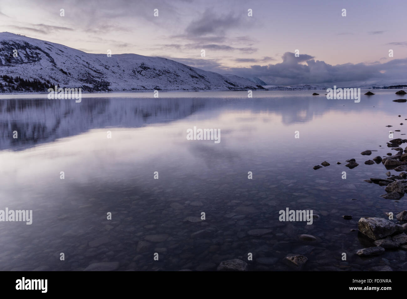 Le lac Tekapo au coucher du soleil avec ciel violet clair, et le lac encore réflexion. Banque D'Images