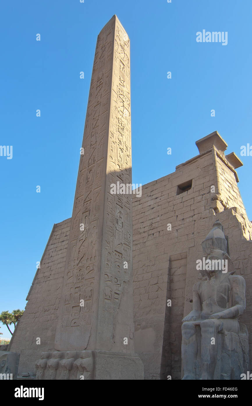 Obélisque égyptien et statue à l'entrée du temple de Karnak Louxor Thèbes antique. Ciel bleu en arrière-plan Banque D'Images