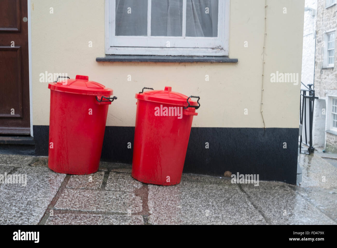 Deux poubelles rouges à l'extérieur d'une maison privée Banque D'Images