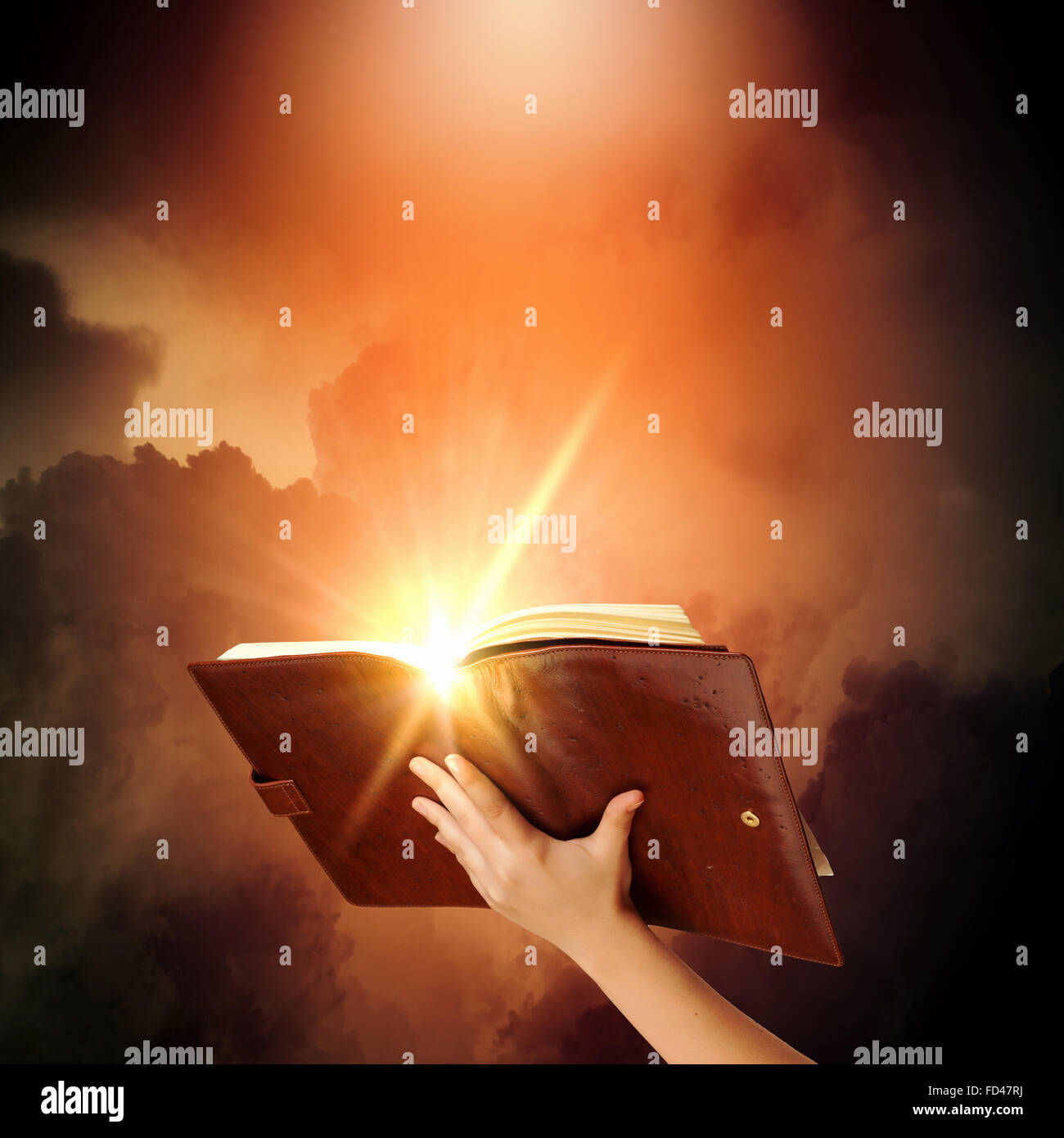 Human hand holding livre de magie avec magic lights Banque D'Images