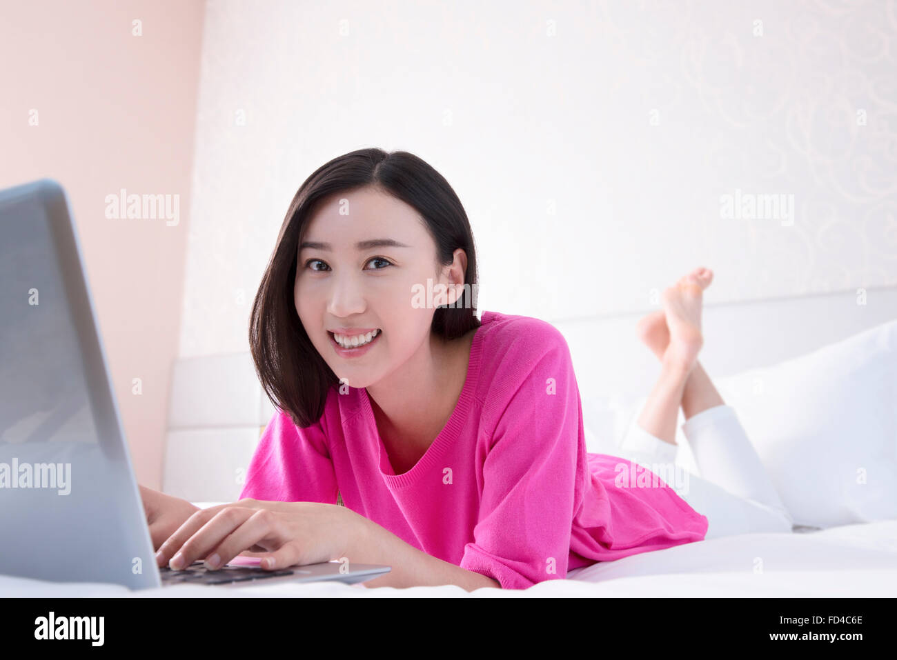 Young woman using laptop in bed Banque D'Images