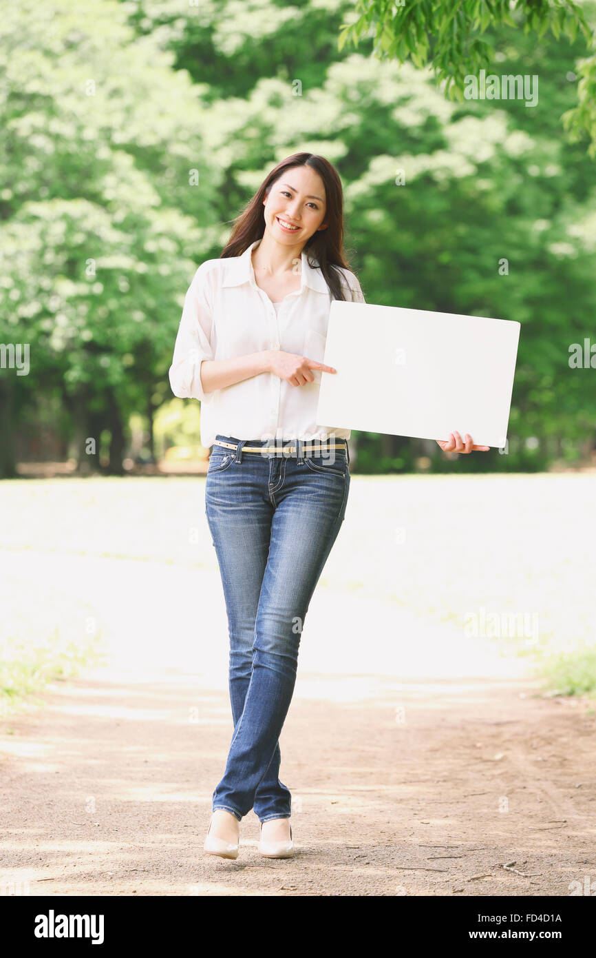 Jolie femme japonaise dans un parc de la ville Banque D'Images