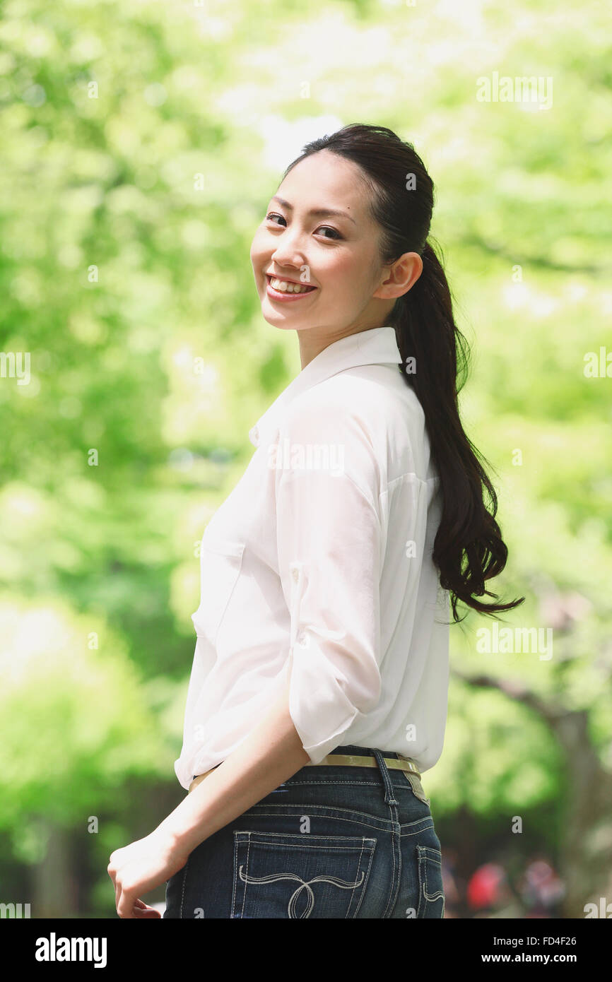 Jolie femme japonaise dans un parc de la ville Banque D'Images