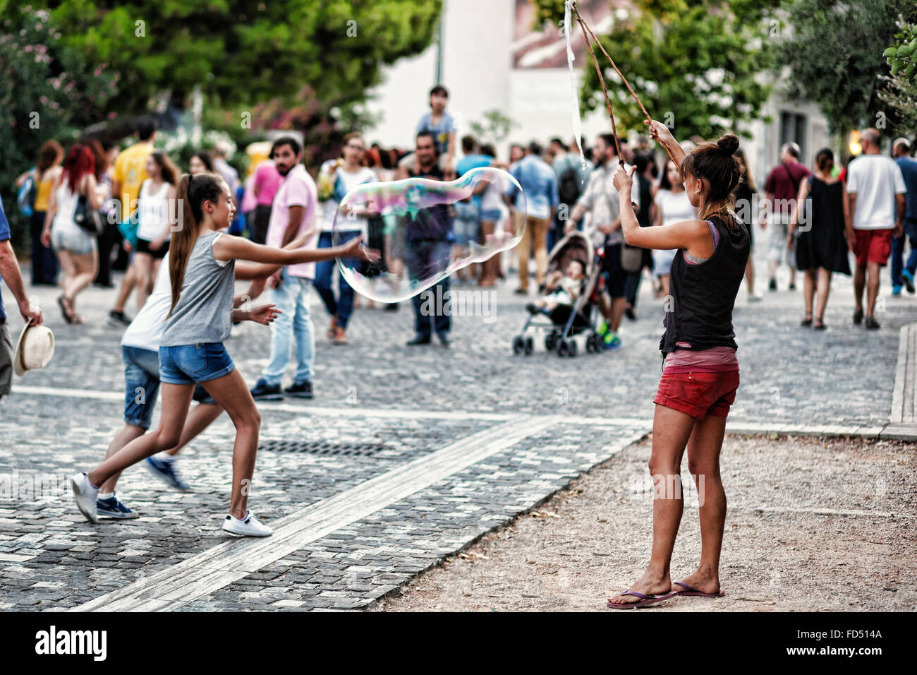 Peu d'enfants qui jouent avec des bulles géantes dans les rues d'Athènes, Grèce Banque D'Images