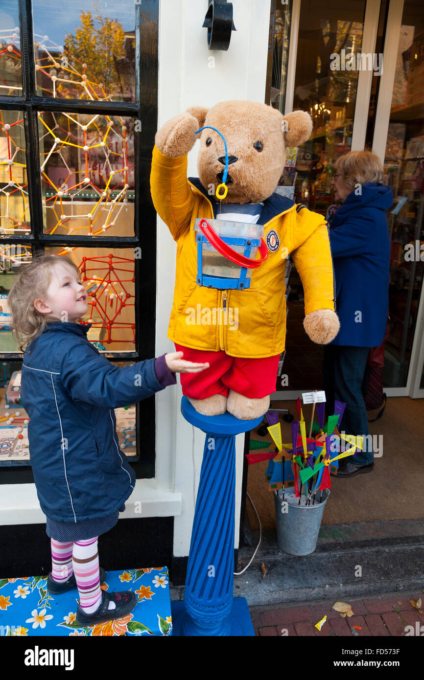 Girl age 3 / 3 ans dans un magasin de jouets à Amsterdam en Hollande, aux  Pays-Bas. Elle joue avec un ours qui souffle une bulle bulles / machine  Photo Stock - Alamy