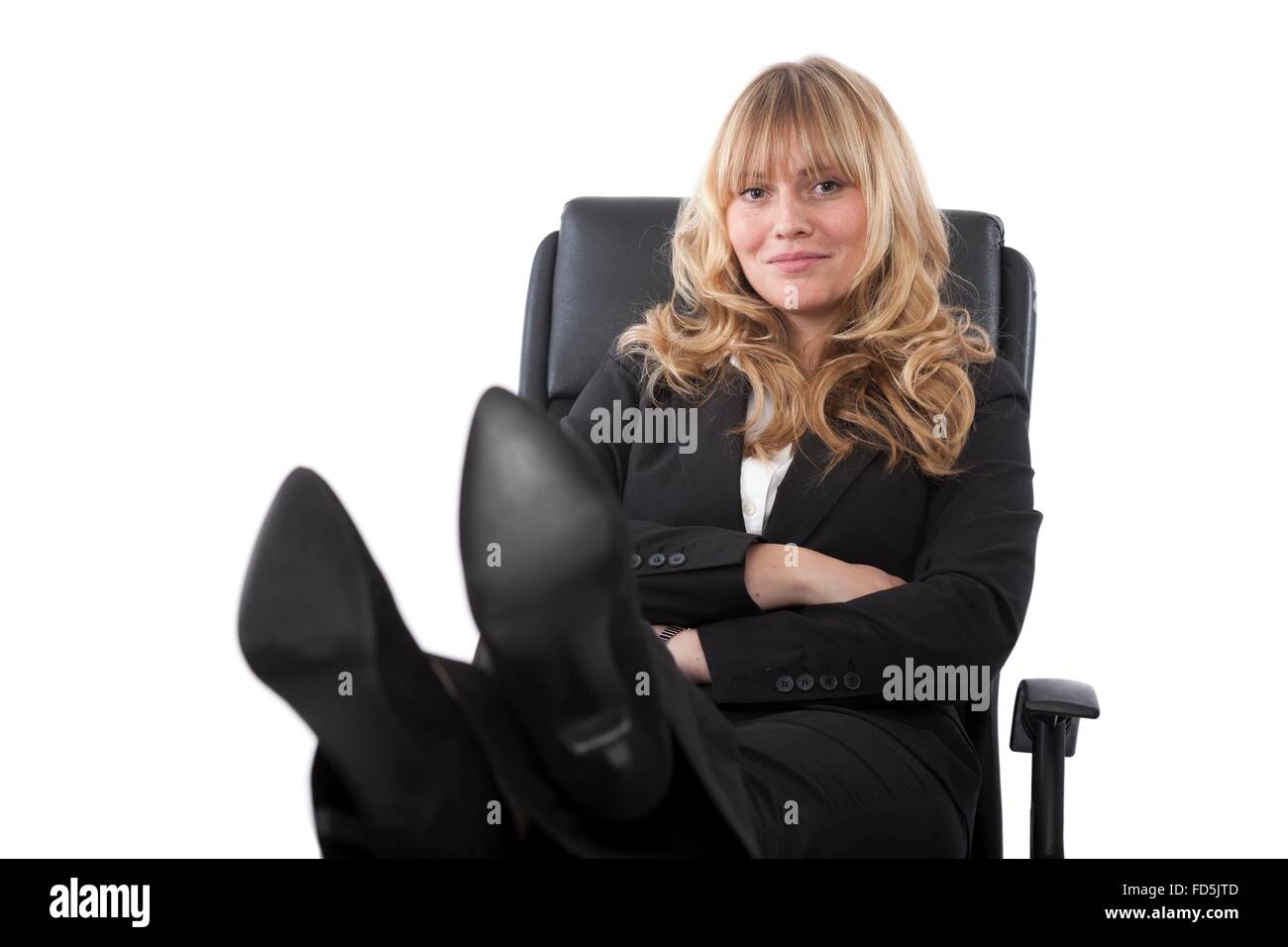 Convaincu de la femme assise avec ses pieds sur son bureau. Banque D'Images