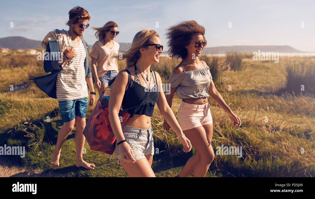 Portrait de groupe des amis Aller à sur la plage. Groupe mixte d'amis marchant sur la plage le jour d'été. Banque D'Images
